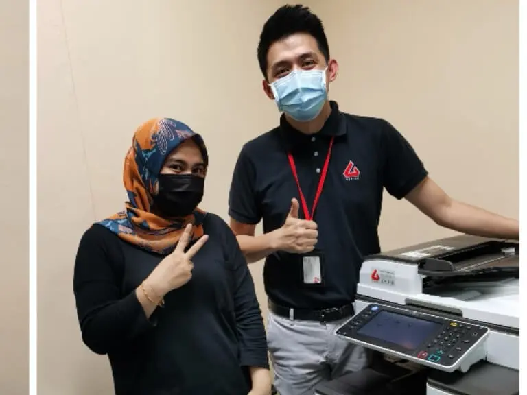 Satisfied customer posing beside a rented Ricoh MPC3503 in Kuala Lumpur